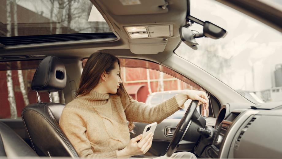 Woman using cell phone in car