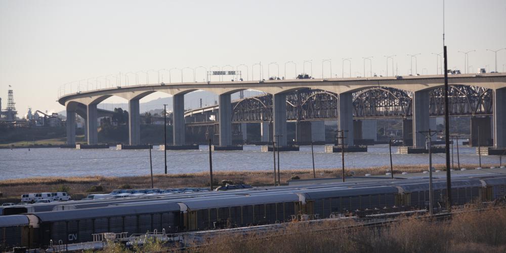 The Benicia-MArtinez Bridge with a train in the foreground.