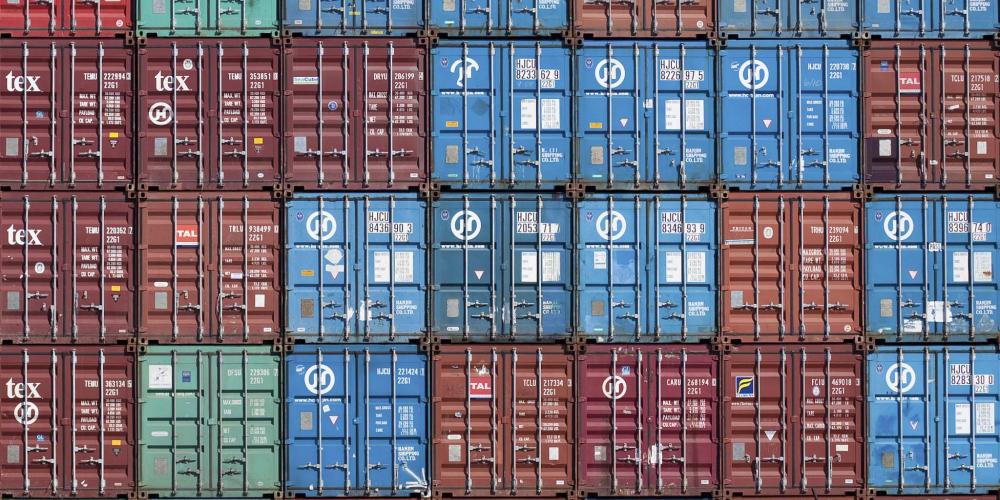 A close-up shot of the ends of 60 cargo shipping containers in various colors.