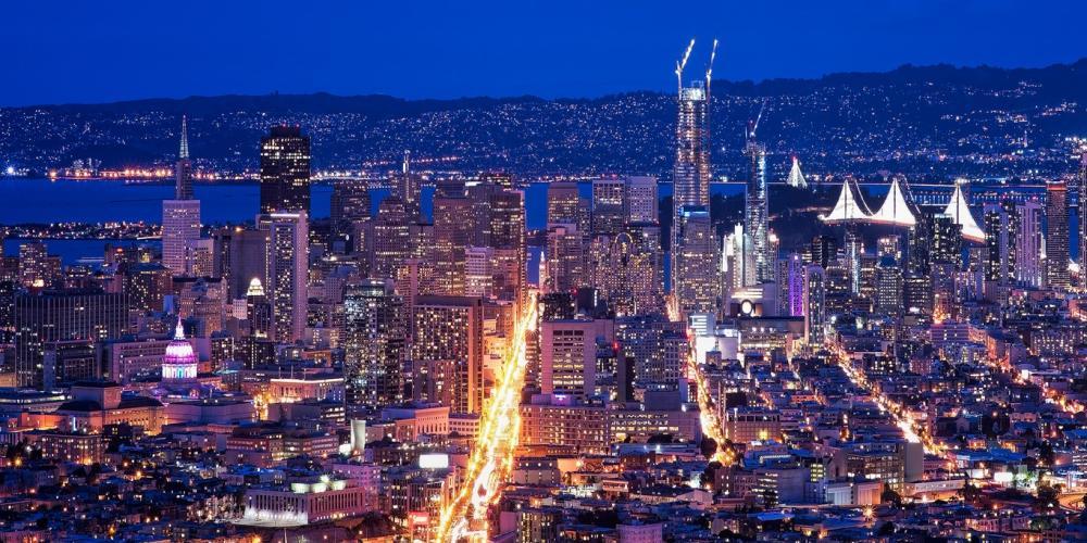 San Francisco cityscape at night, including Market Street, Salesforce Tower and the Bay Lights.