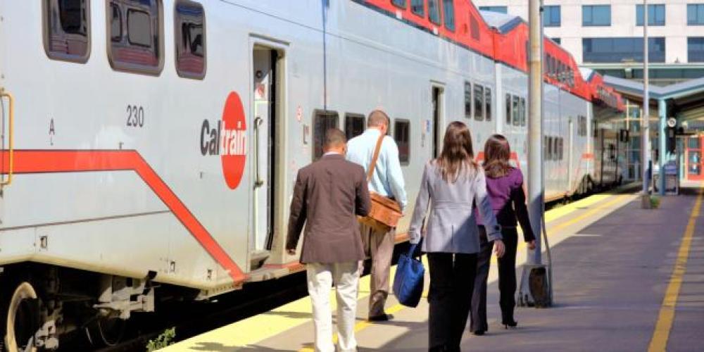 passengers walking alongside a caltrain car to load 