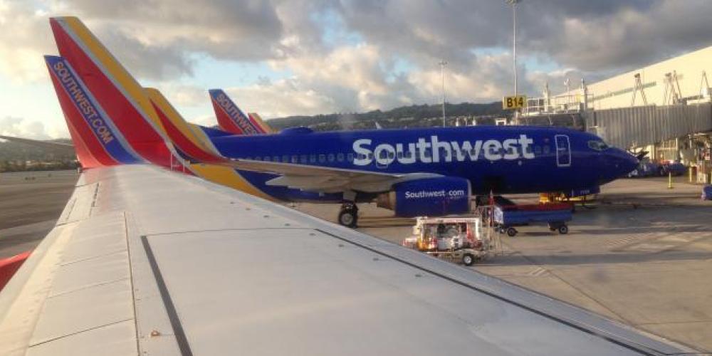 looking over the wing of a southwest airplane at other soutwest planes