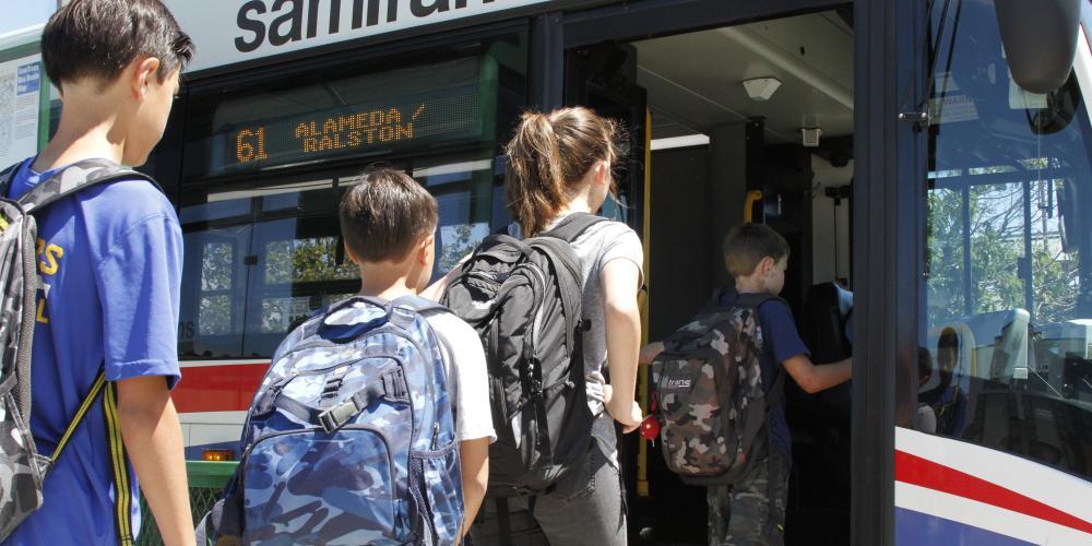 Kids with backpacks board the 61 Alameda/Ralston SamTrans bus.