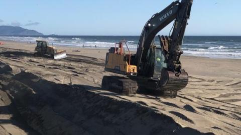 construction equipment moving sand on ocean beach